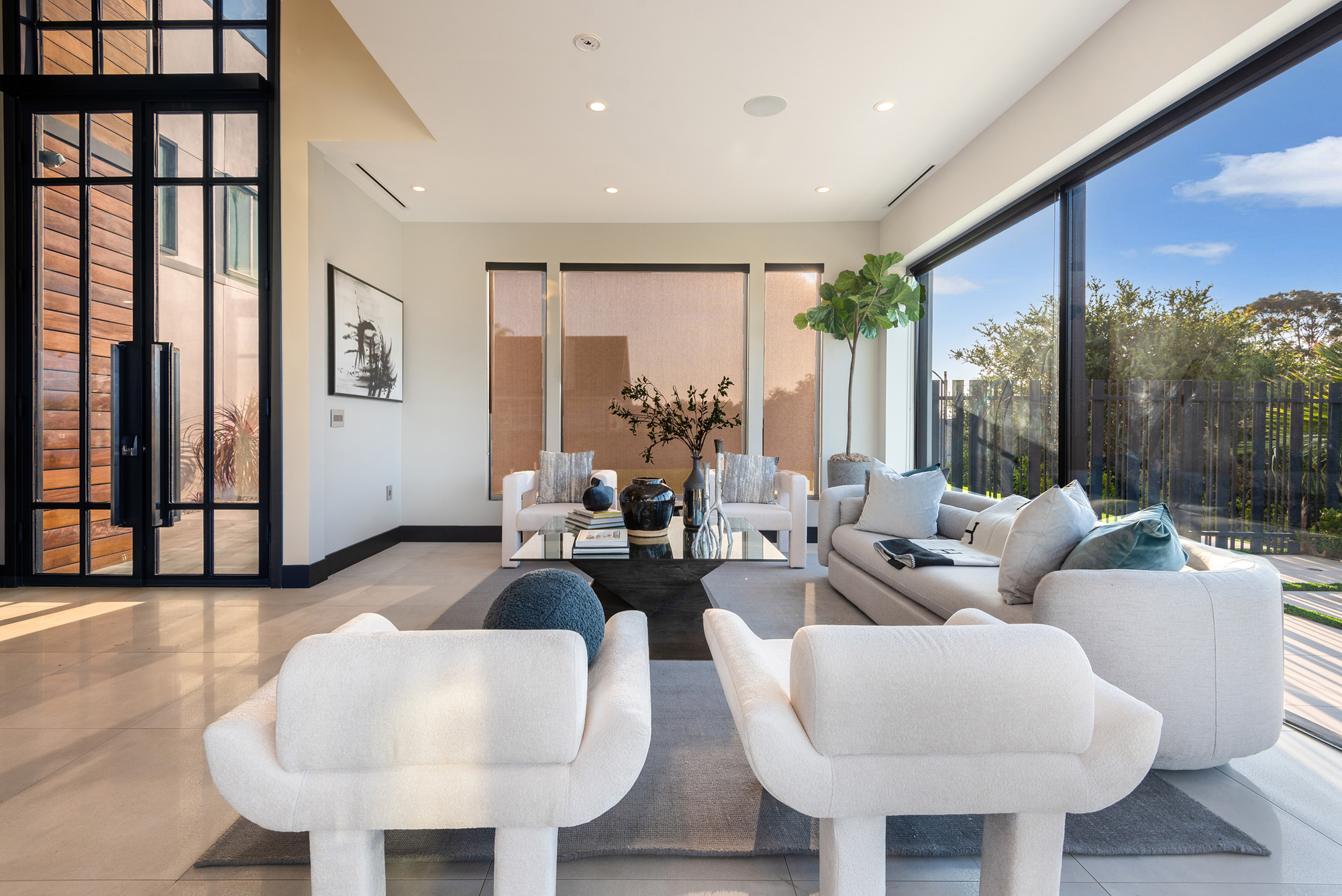 Gayle Quinta — living room with sculptural seating and steel doors