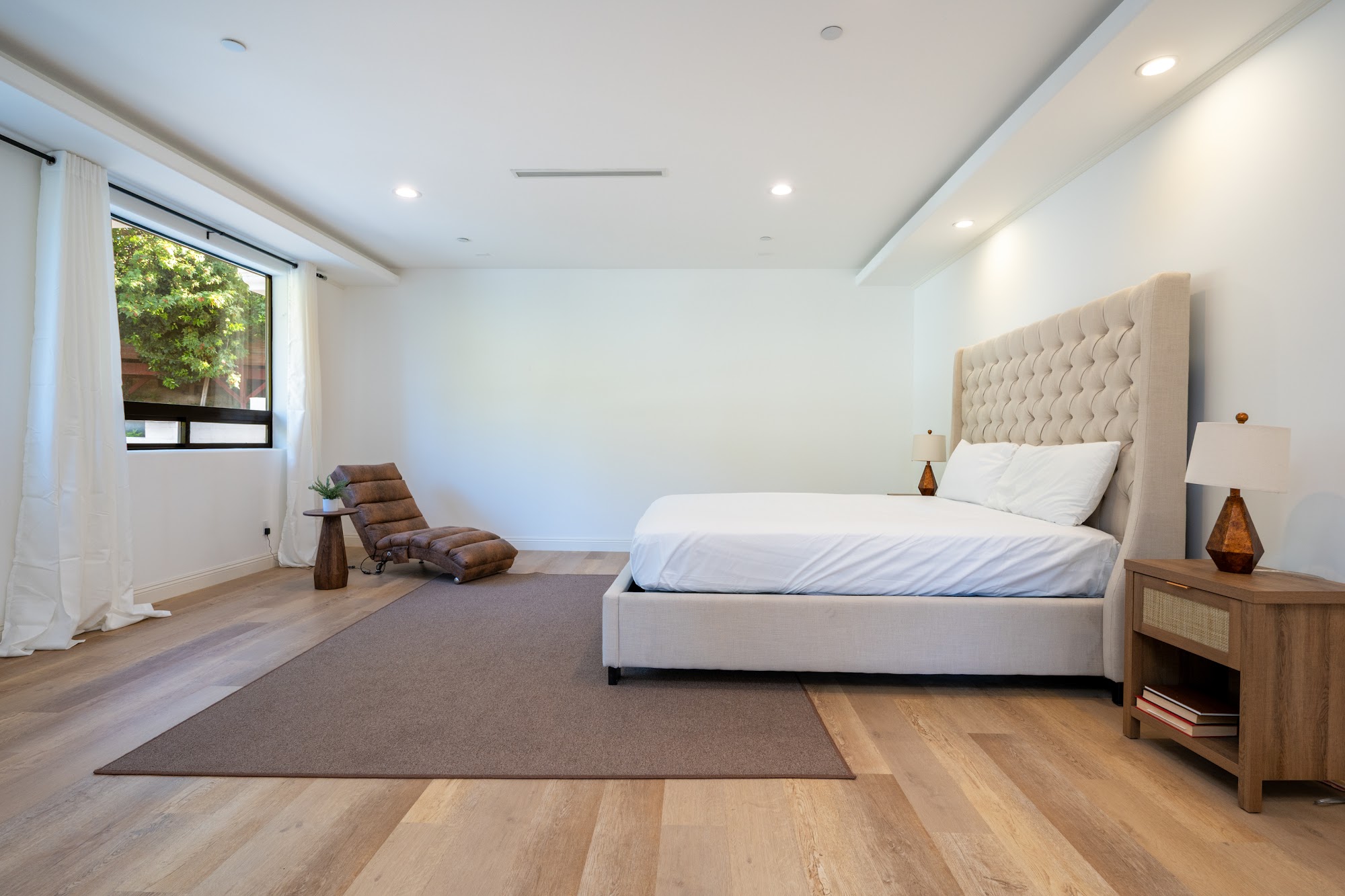 Grimes Olive House — bedroom with upholstered headboard