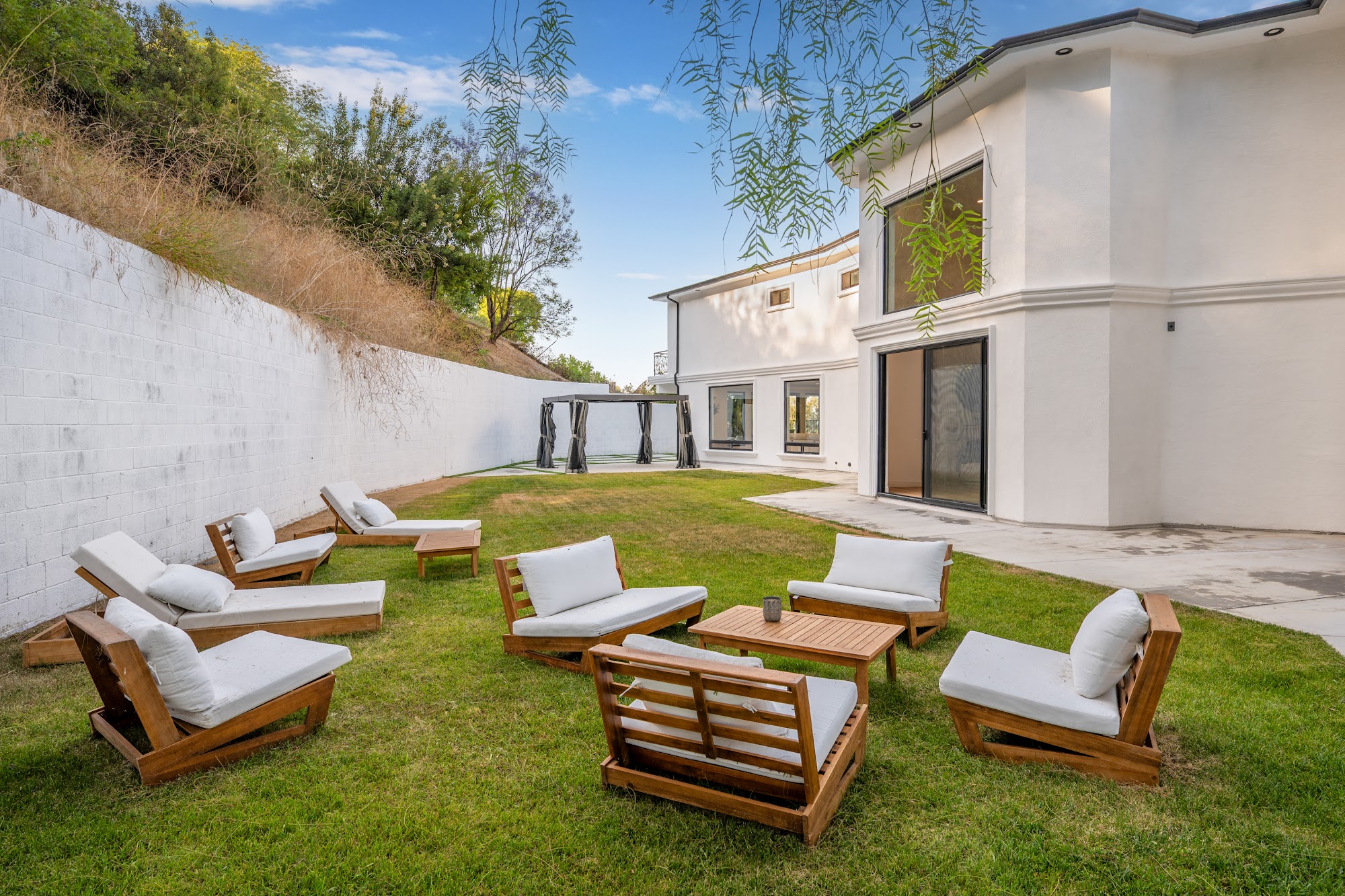 Grimes Olive House — lawn with loungers below the hillside