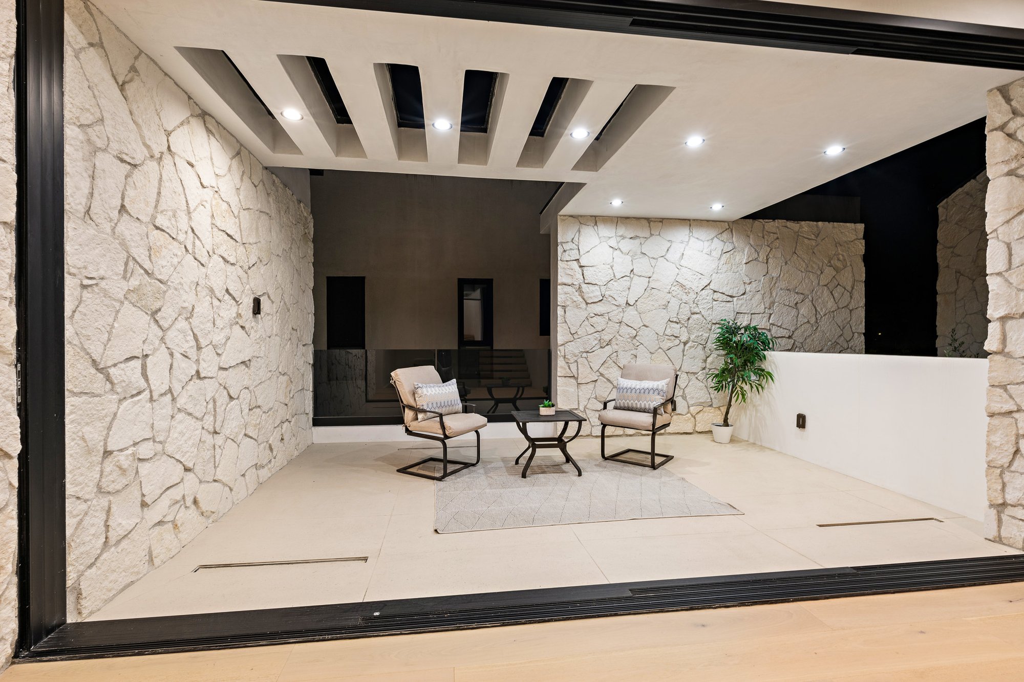 Curson Atelier — covered entry courtyard with stone wall